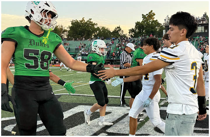 A group of football players on a field. Description generated by AI