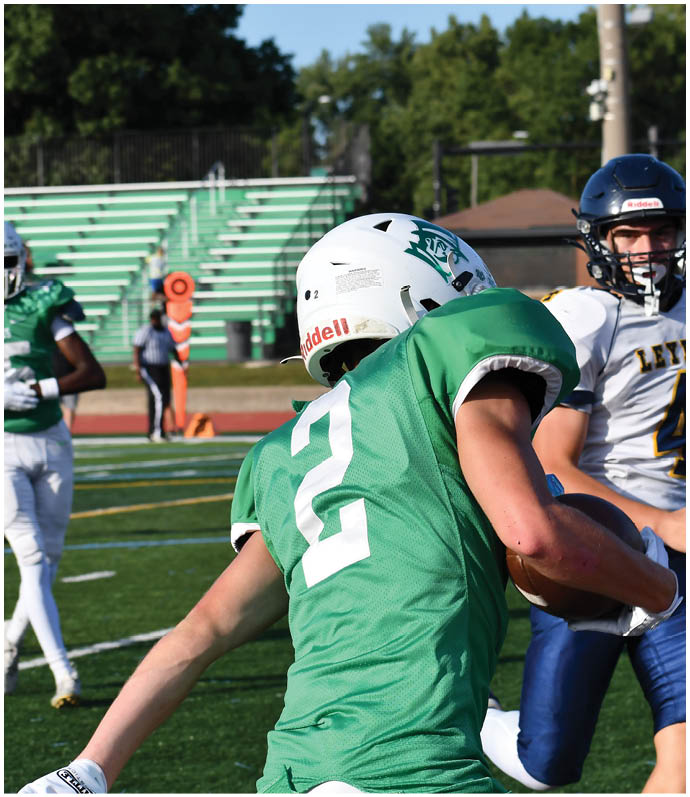 Three football players in blue and white uniforms running on a field. Description generated by AI