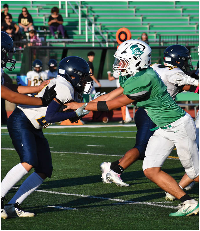 Three football players in blue and white uniforms running on a field. Description generated by AI