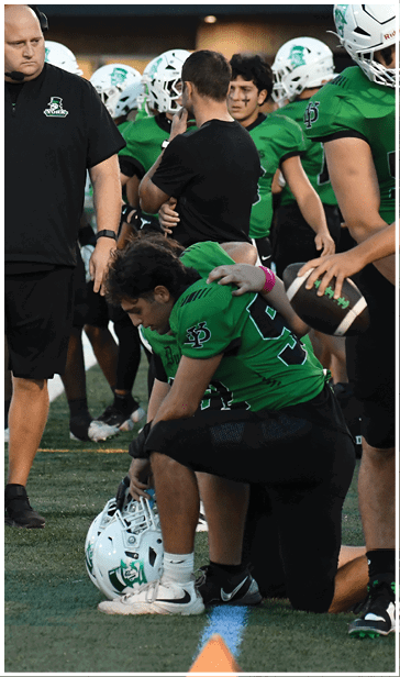 A group of football players on a field. Description generated by AI