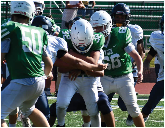 Three football players in blue and white uniforms running on a field. Description generated by AI