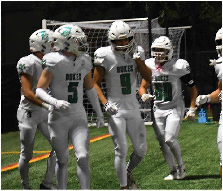 A group of football players on a field. Description generated by AI
