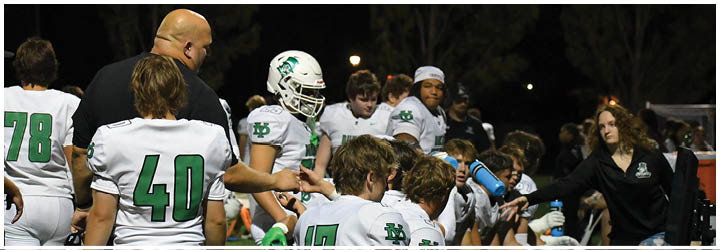 A group of football players on a field. Description generated by AI