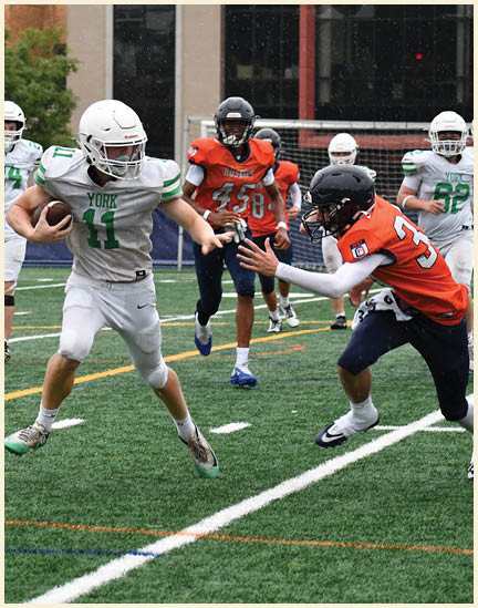 A football player wearing a black jersey with the number 11 on it. Description generated by AI