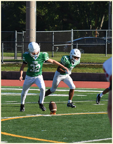 A football player wearing a black jersey with the number 11 on it. Description generated by AI
