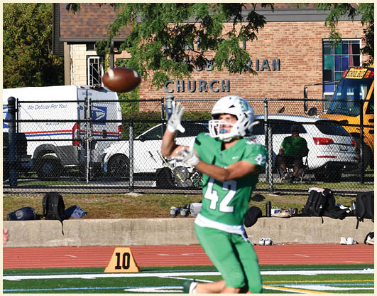 A football player is kicking a football on a field. Description generated by AI