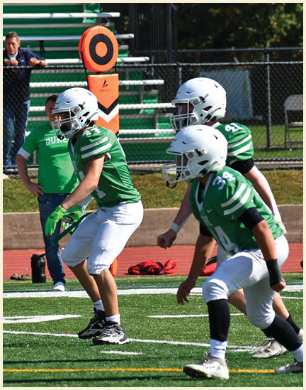 A football player wearing a black jersey with the number 11 on it. Description generated by AI