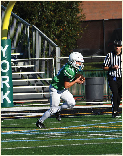 A football player wearing a black jersey with the number 11 on it. Description generated by AI