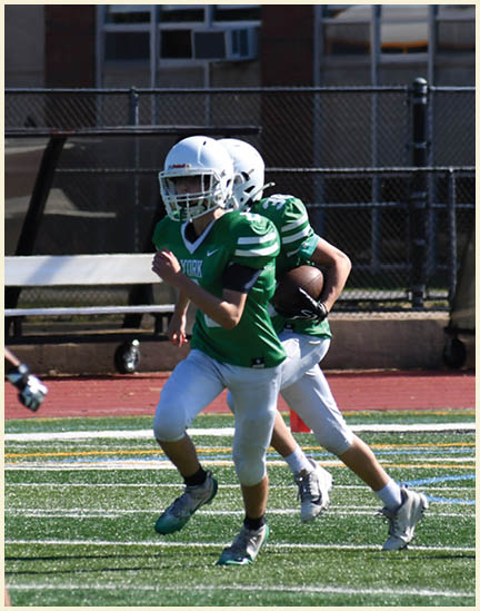 A football player wearing a black jersey with the number 11 on it. Description generated by AI
