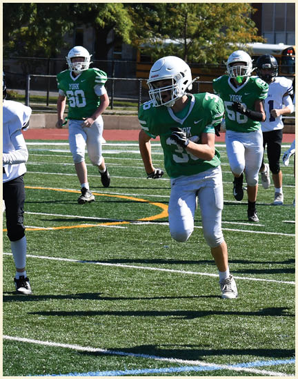 A football player wearing a black jersey with the number 11 on it. Description generated by AI