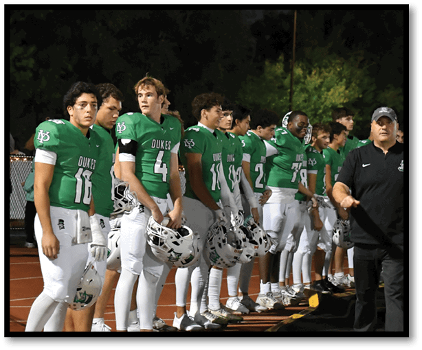 A group of football players wearing black jerseys with the number 3 on them. Description generated by AI