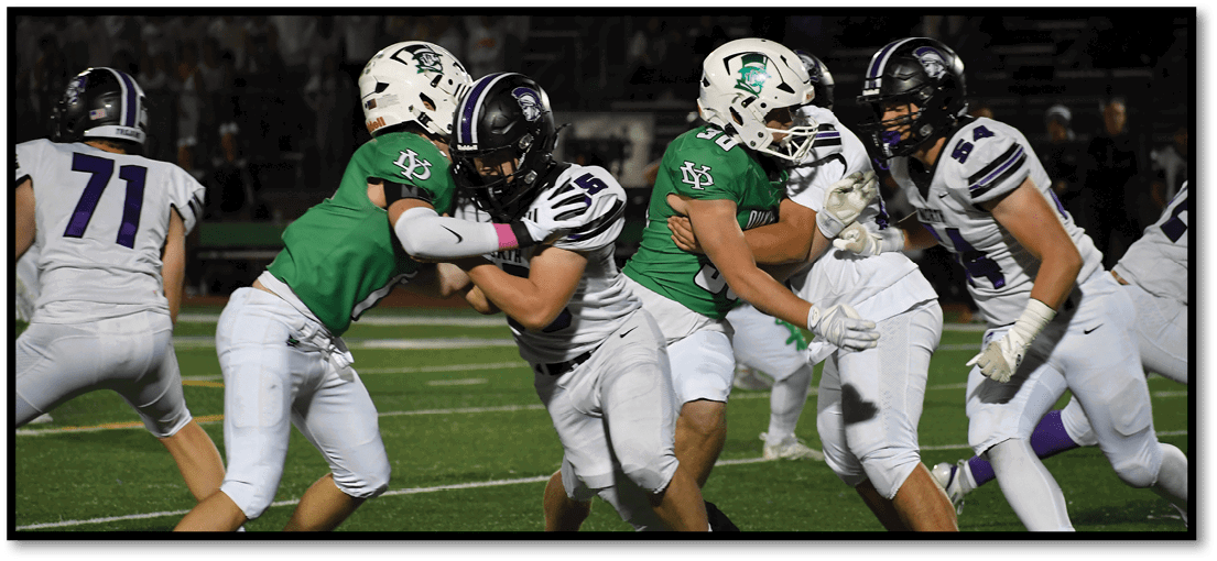 A group of football players on a field. Description generated by AI