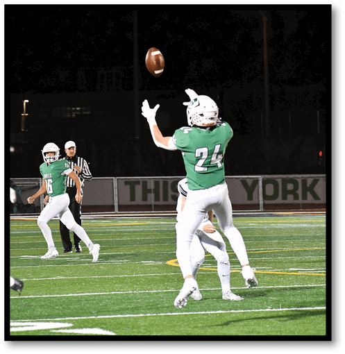 A football player wearing a black jersey with the number 6 on it. Description generated by AI