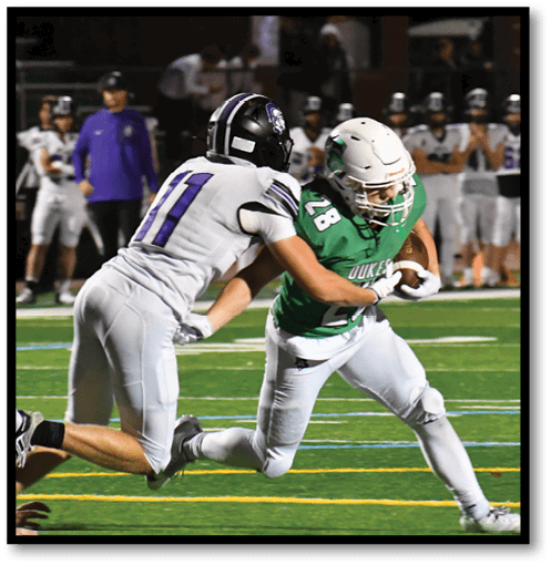 A football player wearing a black jersey with the number 6 on it. Description generated by AI