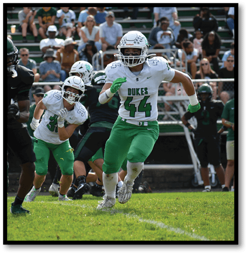 A football player wearing a black jersey with the number 6 on it. Description generated by AI