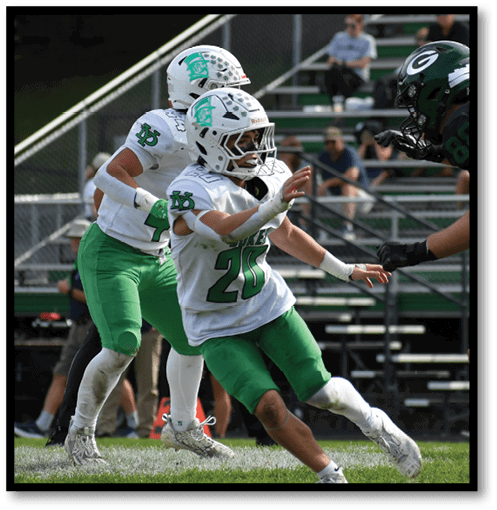 A football player wearing a black jersey with the number 6 on it. Description generated by AI