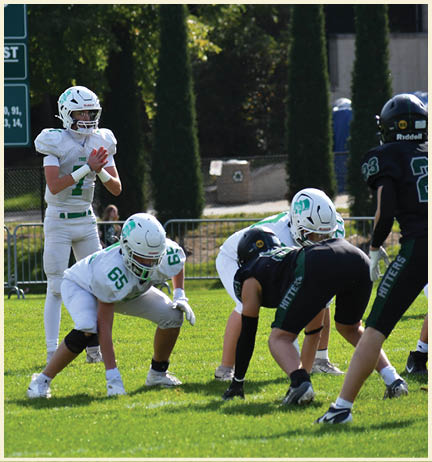 A football player wearing a black jersey with the number 11 on it. Description generated by AI