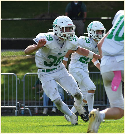 A football player wearing a black jersey with the number 11 on it. Description generated by AI