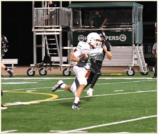 A football player is kicking a football on a field. Description generated by AI