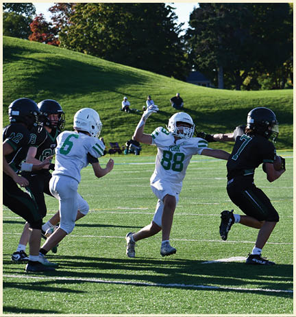 A football player wearing a black jersey with the number 11 on it. Description generated by AI