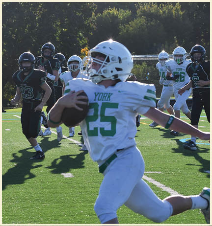 A football player wearing a black jersey with the number 11 on it. Description generated by AI