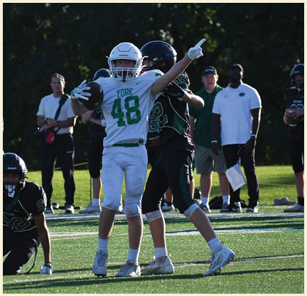 A football player wearing a black jersey with the number 11 on it. Description generated by AI