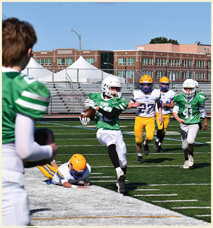 A football player wearing a black jersey with the number 11 on it. Description generated by AI
