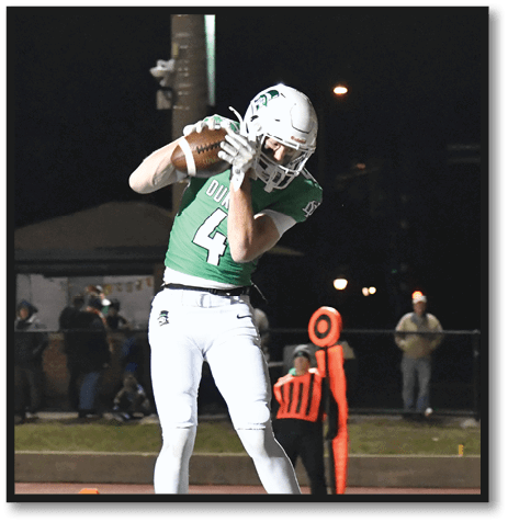 A football player wearing a black jersey with the number 6 on it. Description generated by AI