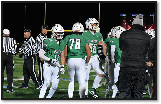A group of football players wearing black jerseys with the number 3 on them. Description generated by AI