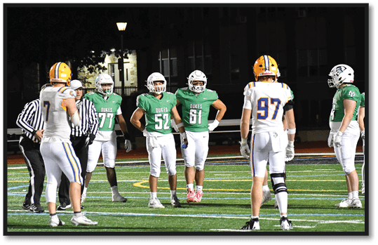 A group of football players wearing black jerseys with the number 3 on them. Description generated by AI