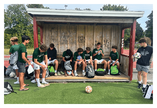 A group of football players wearing headphones and smiling. AI generated content