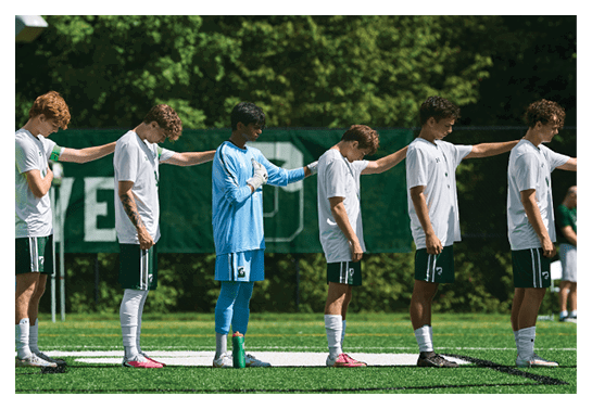 A group of people are kneeling on a field, possibly in a football game. AI generated content