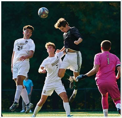 A football game is taking place with a group of men on the field. Description generated by AI