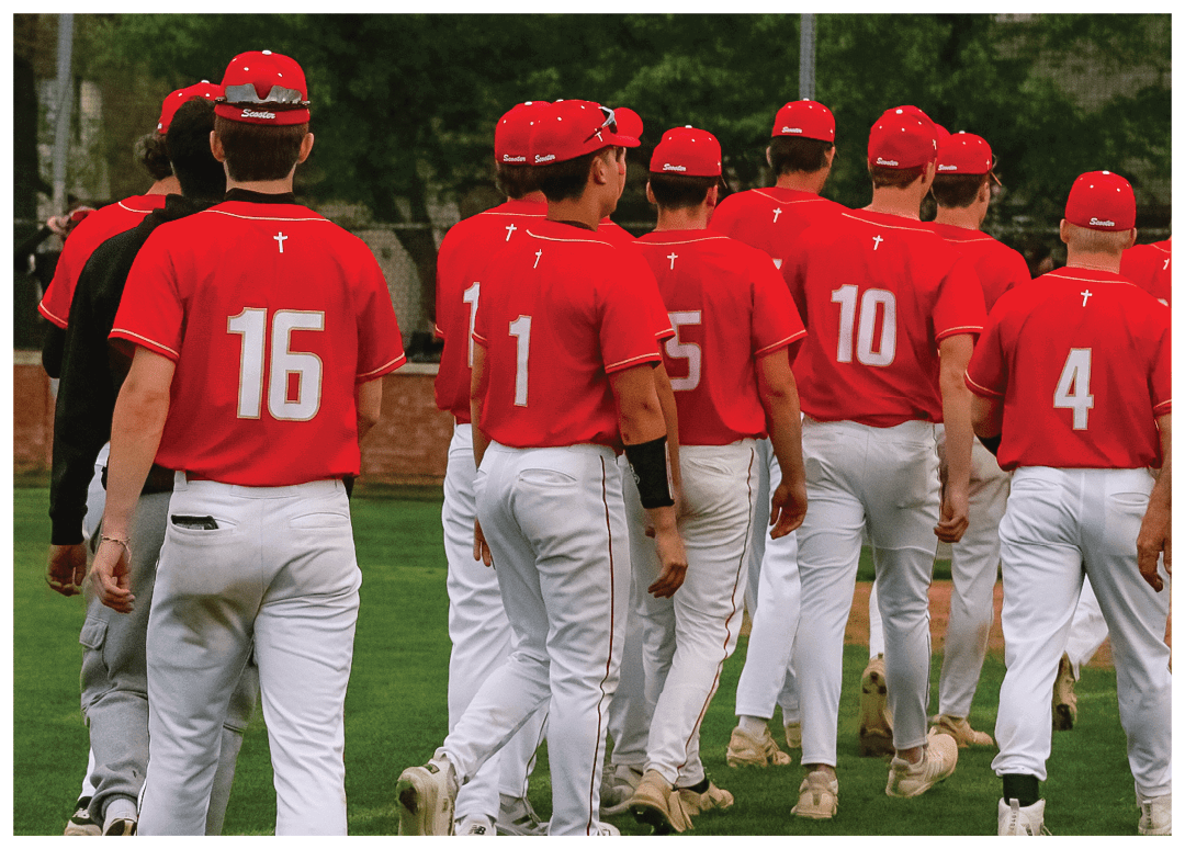 A group of baseball players wearing red shirts and white pants. Description generated by AI