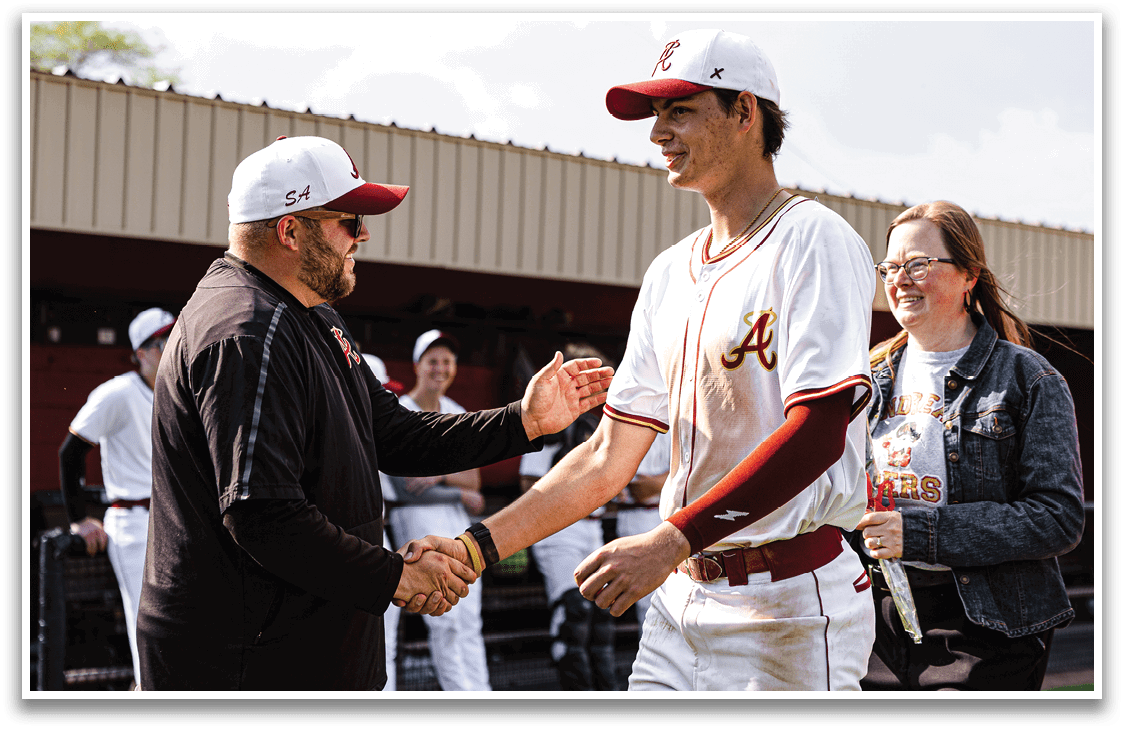 A man wearing a baseball uniform shakes hands with another man. Description generated by AI