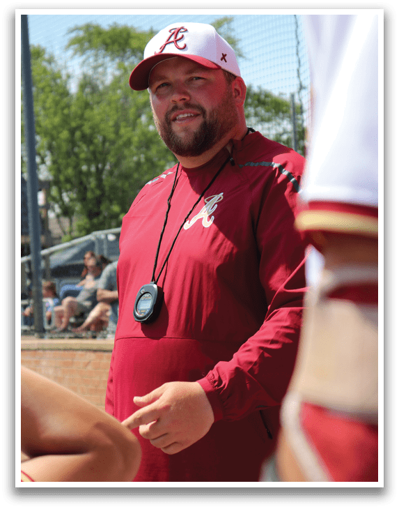 A man wearing a red shirt and a baseball cap. Description generated by AI