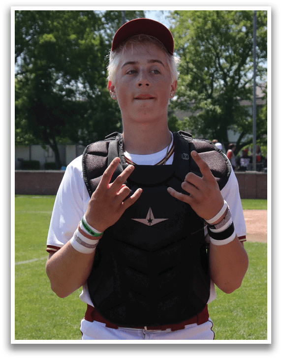 A boy wearing a baseball uniform and a helmet. Description generated by AI