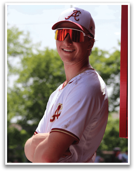 A baseball player wearing a white and red uniform. Description generated by AI