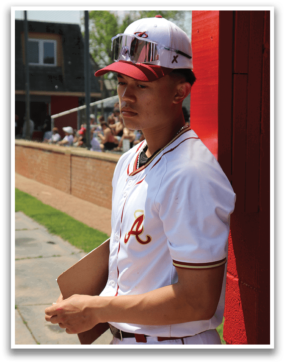 A baseball player wearing a red and white uniform. Description generated by AI