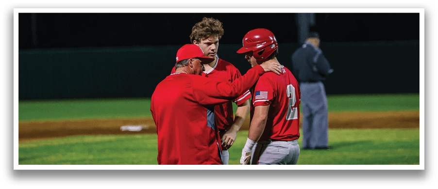 Three men in red and white uniforms are standing on a baseball field. One of them is wearing a red hat. They are engaged in conversation with each other. AI generated content
