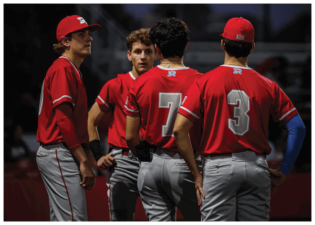 Four baseball players wearing red uniforms are standing on a field. AI generated content