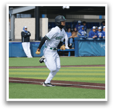 A baseball player wearing a green and white uniform is running to first base. AI generated content