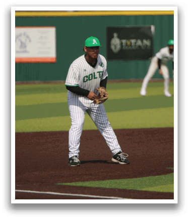 A baseball player in a green shirt and white pants is standing on the field, holding a baseball glove. Another player is running towards him. AI generated content