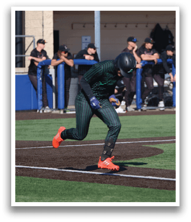 A baseball player is running towards home plate, wearing a green and black uniform. AI generated content