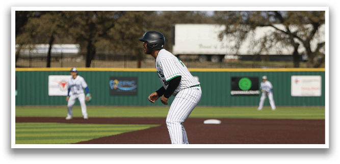 A baseball player in a white and green uniform is standing on the field, holding a baseball bat. AI generated content