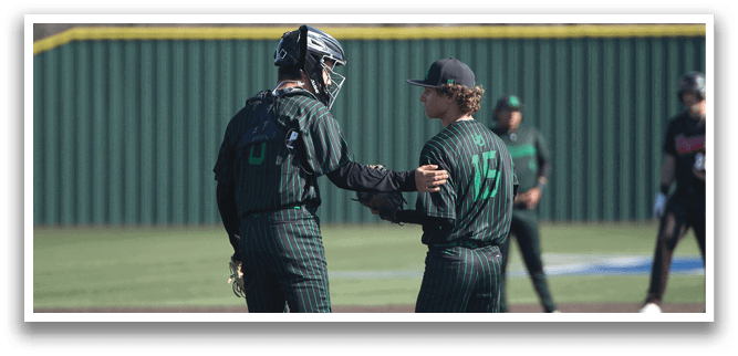Two baseball players wearing green and black uniforms are shaking hands on the field. AI generated content