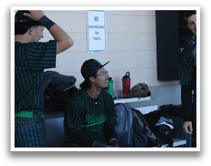 Three baseball players sitting on a bench, one wearing a green jersey. AI generated content