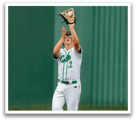 A baseball player wearing a green and white uniform catching a ball. Description generated by AI