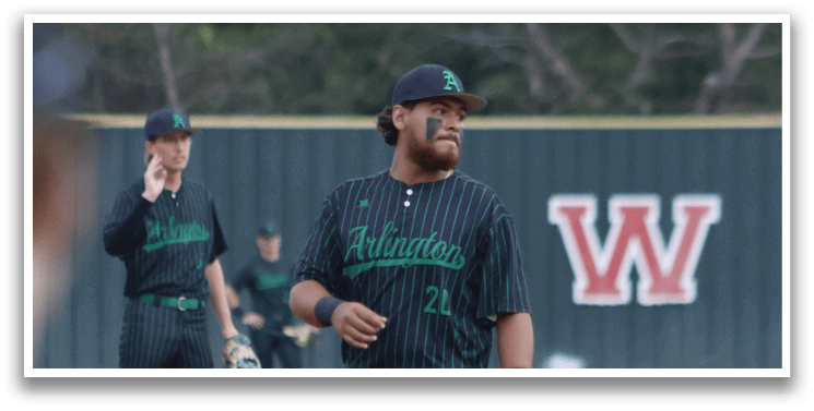 A baseball player wearing a black and green shirt and hat. Description generated by AI