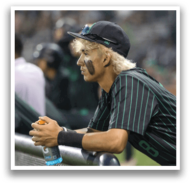 A baseball player with a black hat and green and black uniform. Description generated by AI